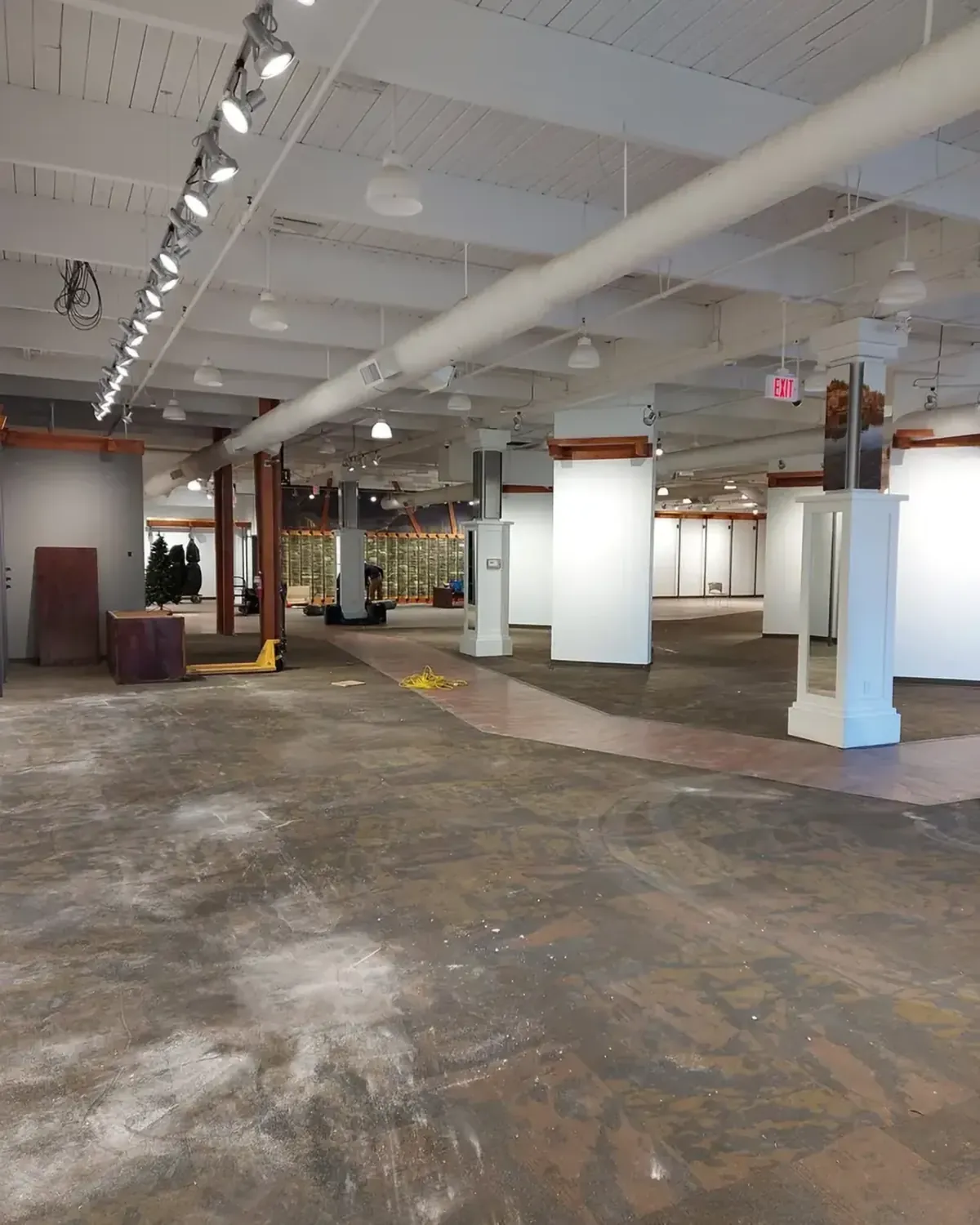 A large commercial unit stripped back to its shell, with old flooring adhesive on the slab