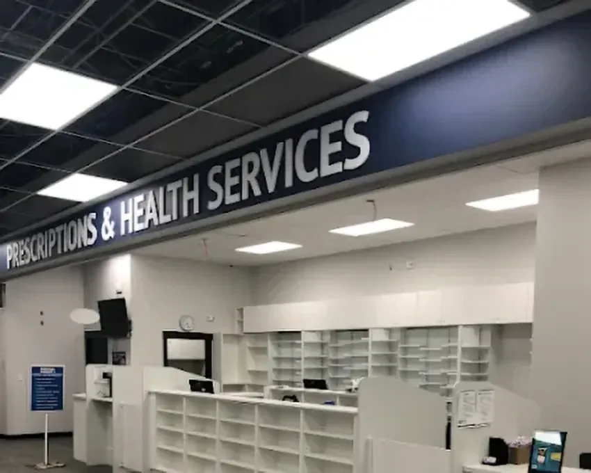 A pharmacy counter under a T-bar ceiling with LED light panels